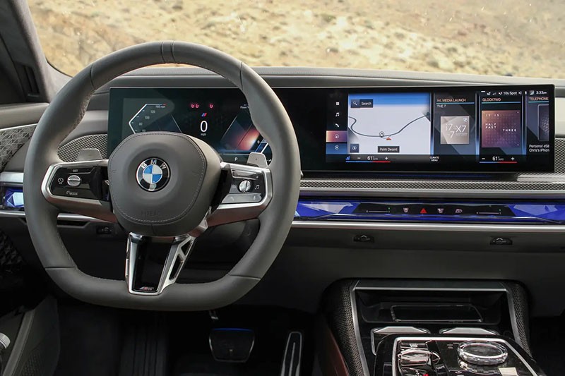 Vô lăng trên BMW 740i 2023 dạng M Sport được bọc da kết hợp loạt phím bấm điều khiển chức năng ở hai bên.