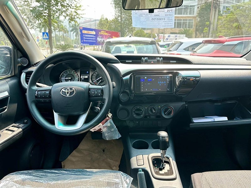 Nội thất của Toyota Hilux 2.4L 4x2 AT 2023 được giữ nguyên như đời cũ ở mức rẻ tiền, thiếu nhiều trang bị so với mức giá.