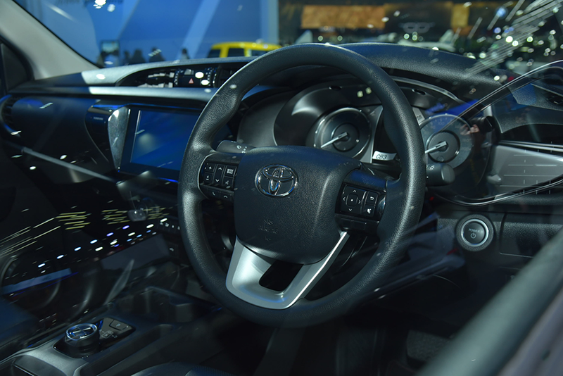 Trung tâm taplo Toyota Hilux Revo BEV Concept 2023 màn hình giải trí đặt ẩn phía trong, bên cạnh bảng điều khiển điều hòa dạng núm xoay truyền thống.