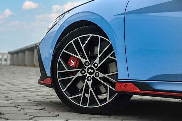 “Dàn chân” của Hyundai Elantra N 2023 là bộ mâm xe có tạo hình cầu kỳ với những đường xiên lắp đầy đường kính 19 inch, bên trong cùm phanh màu đỏ thể thao. 