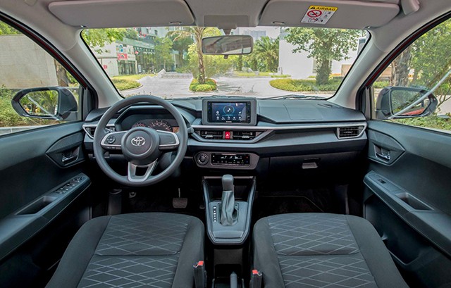 Khoang lái của Toyota Wigo 2023 vẫn hướng đến sự thực dụng khi vô-lăng thường với bọc nhựa có chi tiết bạc.